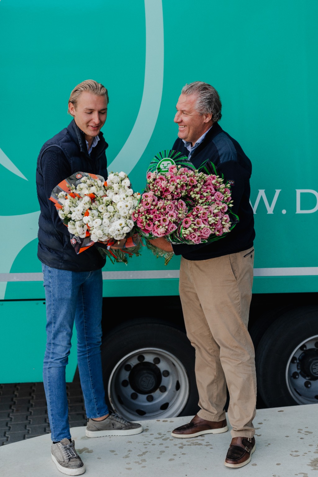 Dirk and Brent handing over bouquets in front of a DL Flowers delivery van